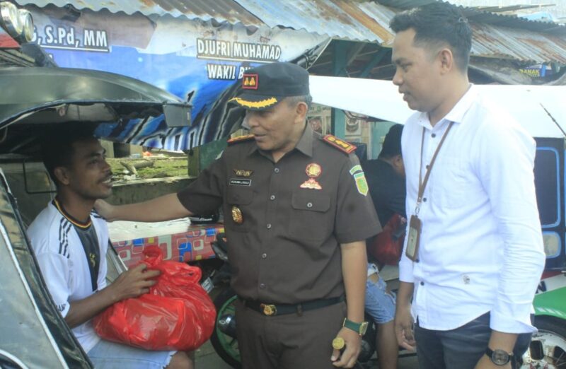 Kepala Kajari yang didampingi oleh staf Bank BSI saat memberikan Sembako Terhadap Pengendara Bentor, (Istimewa). 