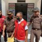 Tersangka RL mengenakan Rompi merah saat keluar dari kantor Kejari Halbar, || Foto: Elang